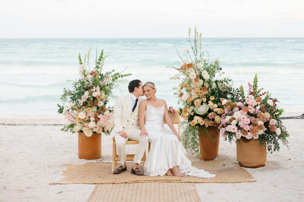 Couple sitting at the altar setup with the ocean in the background — Riviera Maya wedding photographer
