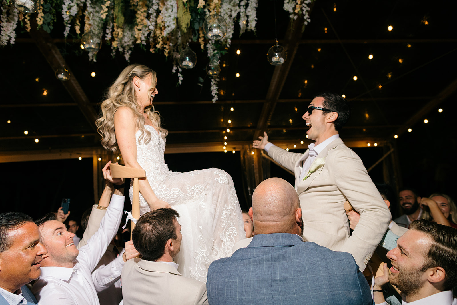 Couple lifted during reception celebration, Riviera Maya wedding photographer