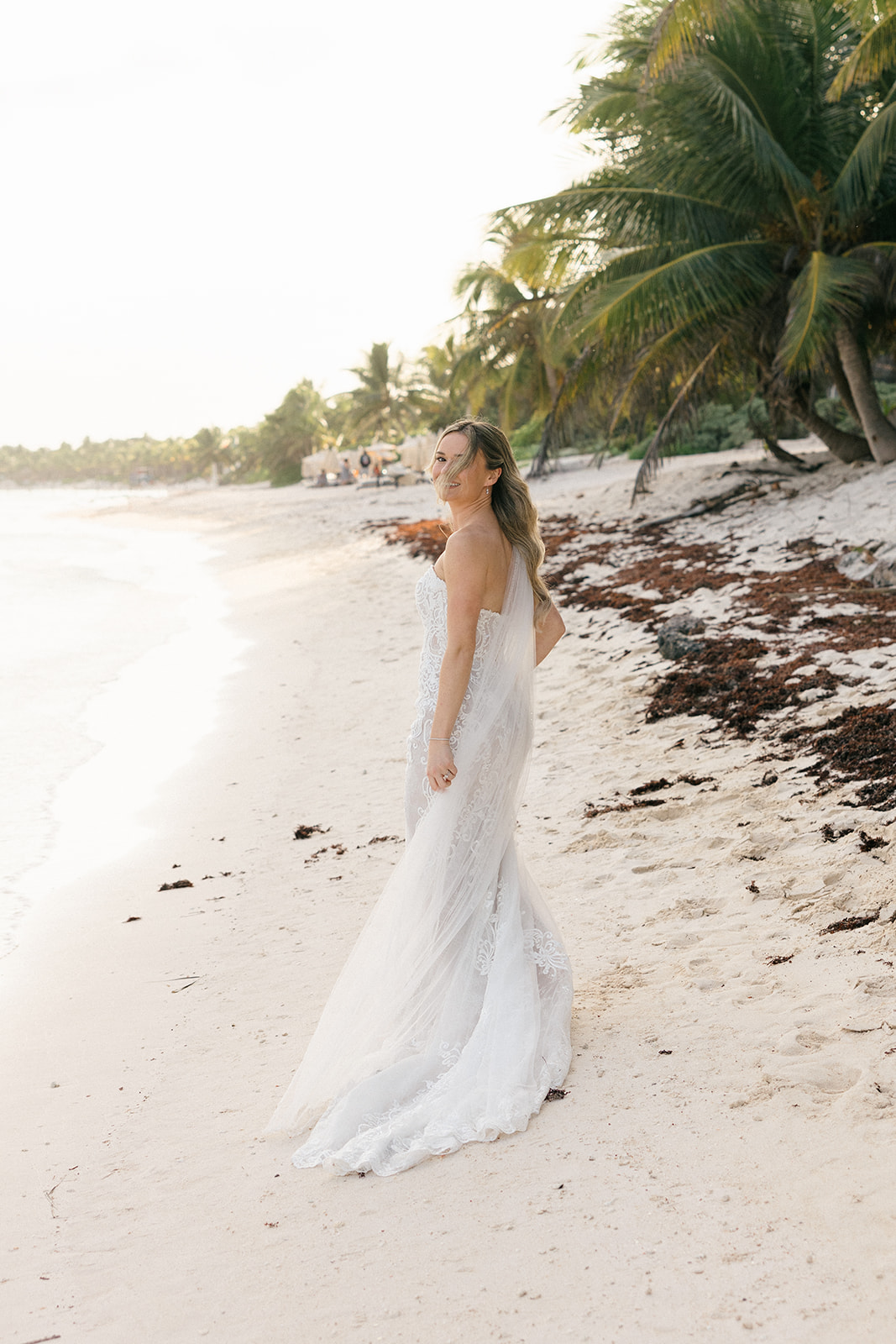 Bride walking on the Caribbean shoreline, Riviera Maya beach wedding